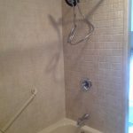 Biscuit tub with subway tile travertine walls